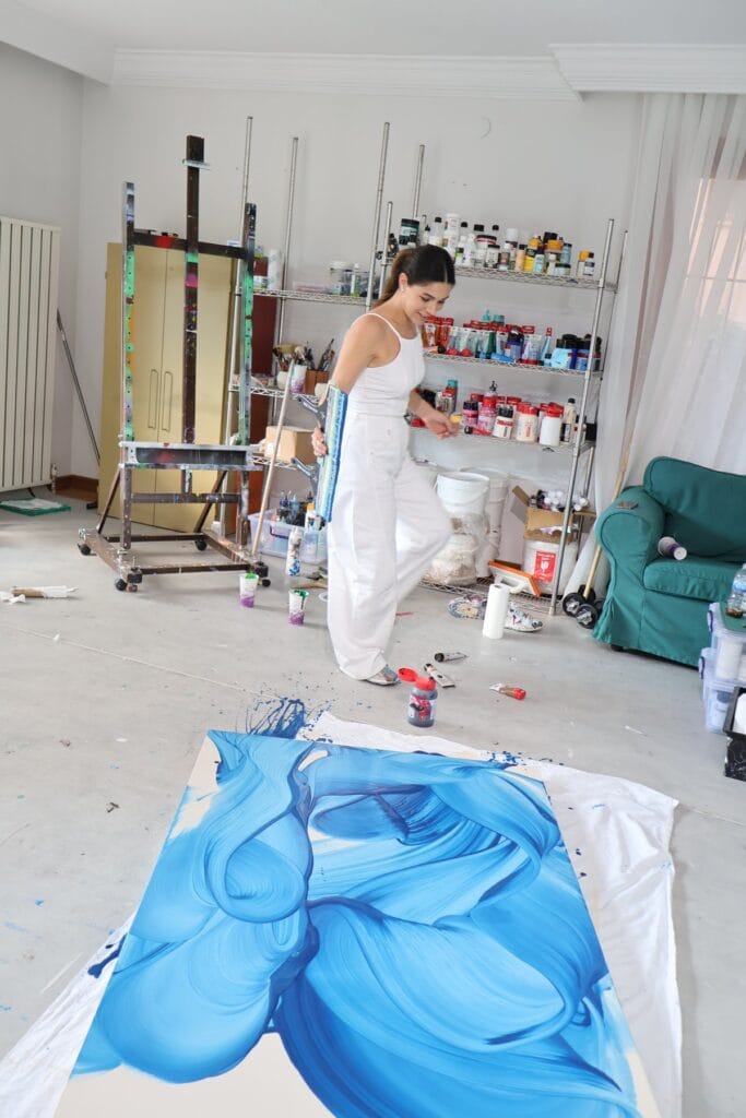 Şebnem Ceylan atölyesinde mavi tonlu büyük bir resmin başında